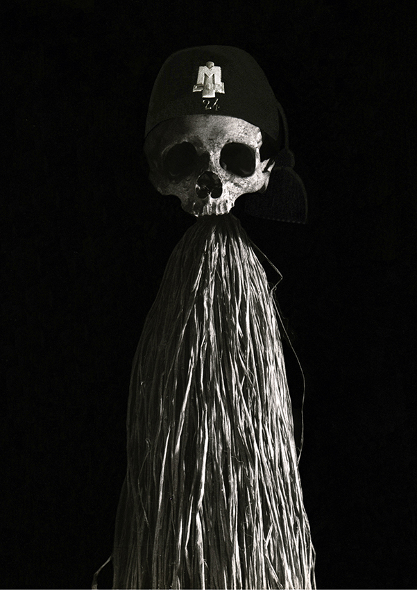 SPAVENTAPASSERI FASCISTA, 1975 - teschio umano, fez (copricapo della divisa fascista), fili di rafia, asta di bambù, cm. 200  